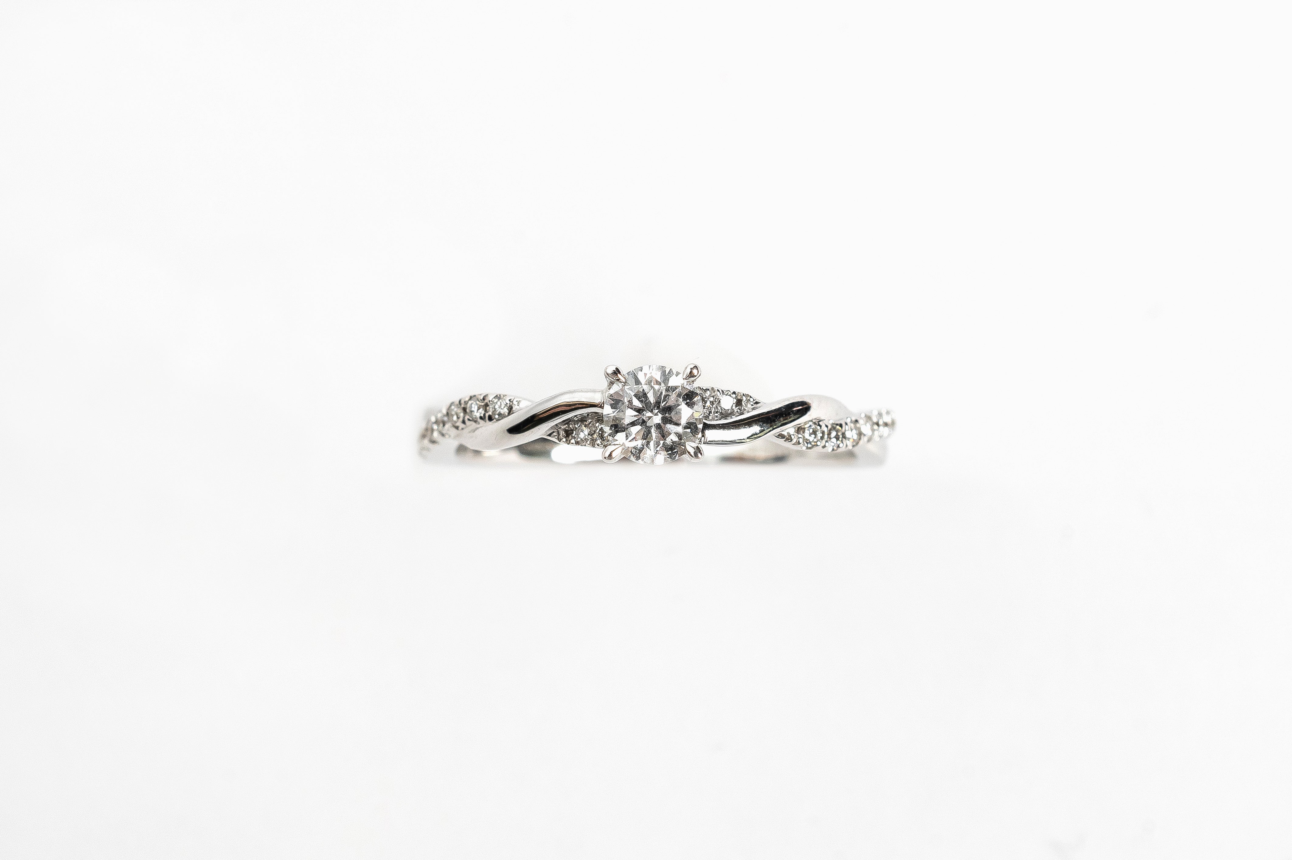 This white gold braided diamond ring is made out of two bands crossing over and over to make a braided twisty design. The crossing band is set with diamonds for a playful result. The beautiful center diamond gives your ring a nice look. 