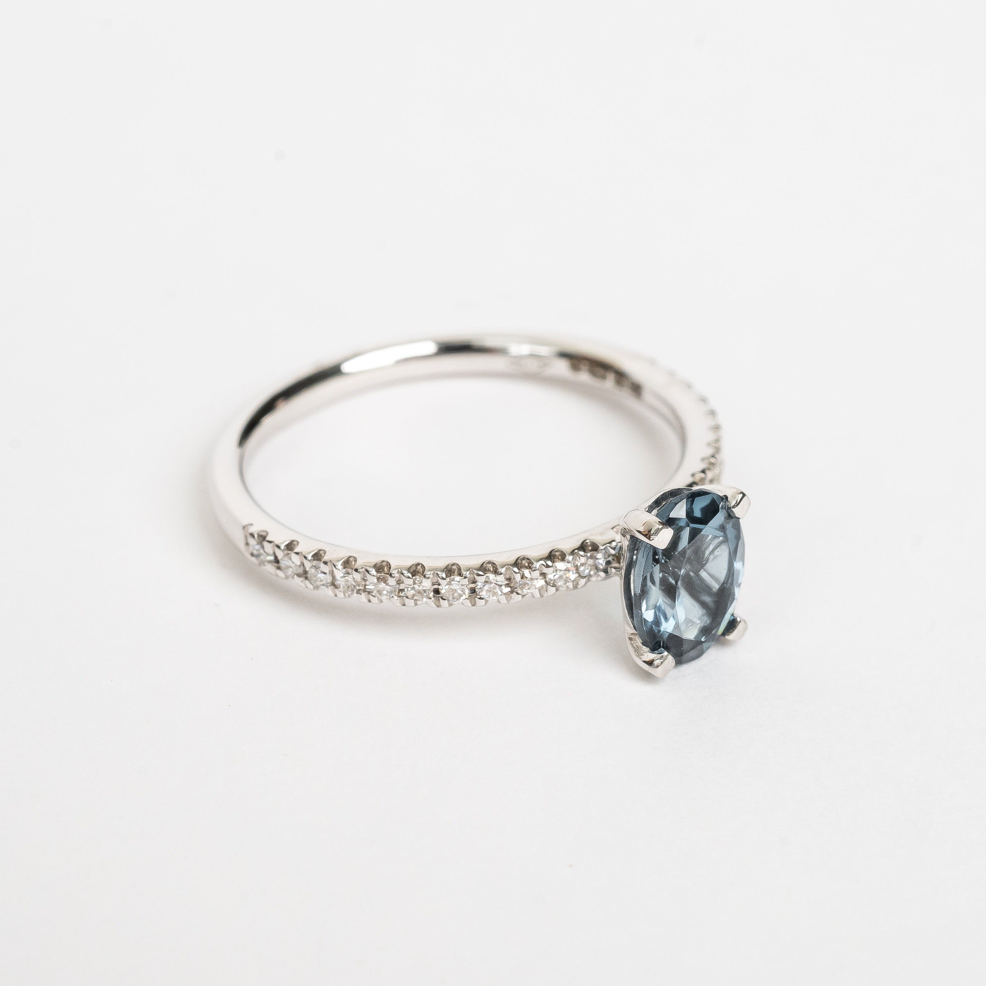 This ring is so beautiful and adds a pop of color to your look. The diamonds set on the band create extra sparkle and honours the oval cut London Topaz.