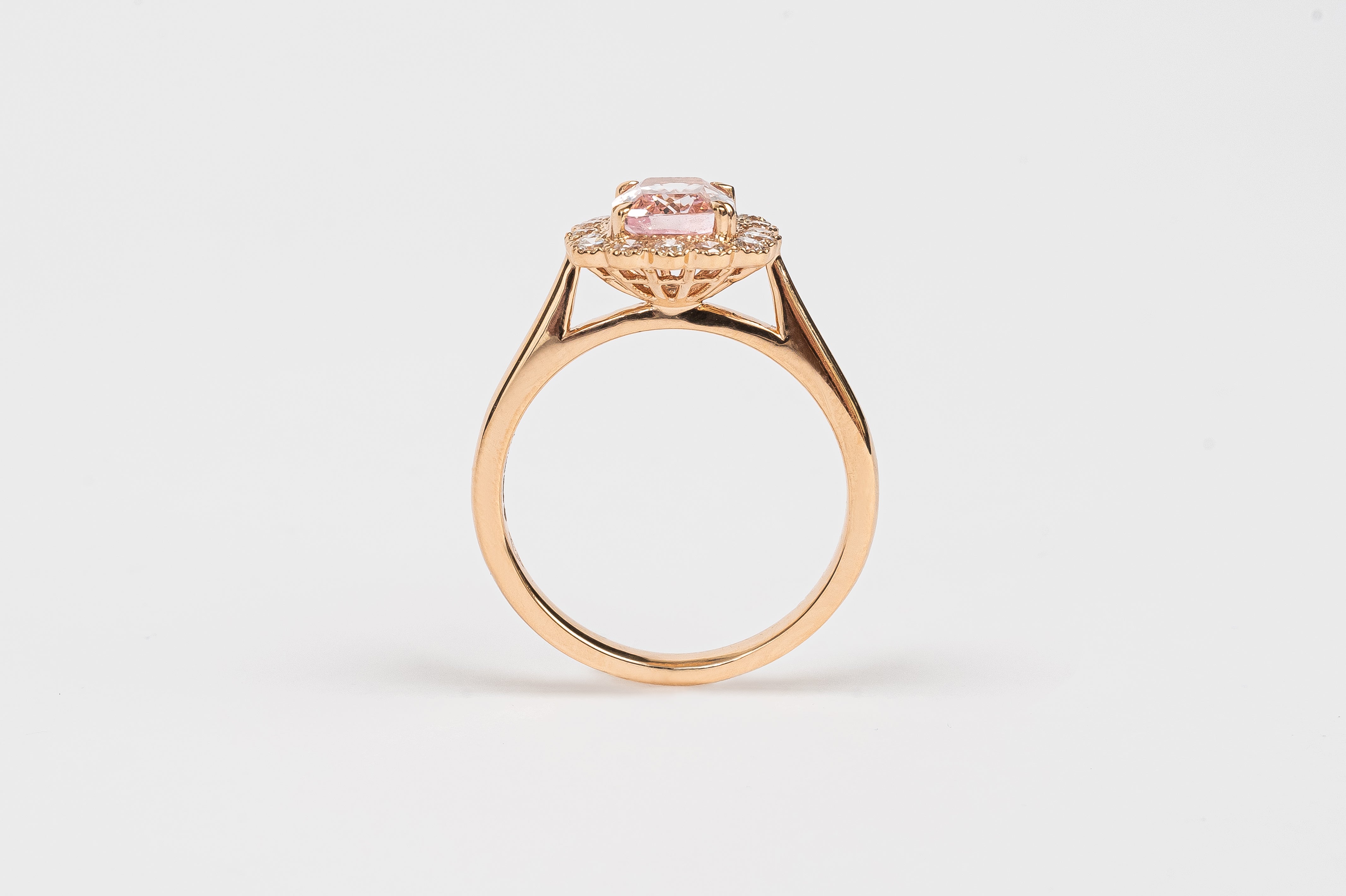 What a beautiful ring! The Morganite is cut in a cushion shape and surrounded by diamond halo of round brilliant diamonds. The soft peachy pink color of the stone matches so beautifully with the rose metal color of the ring.   18kt rose gold