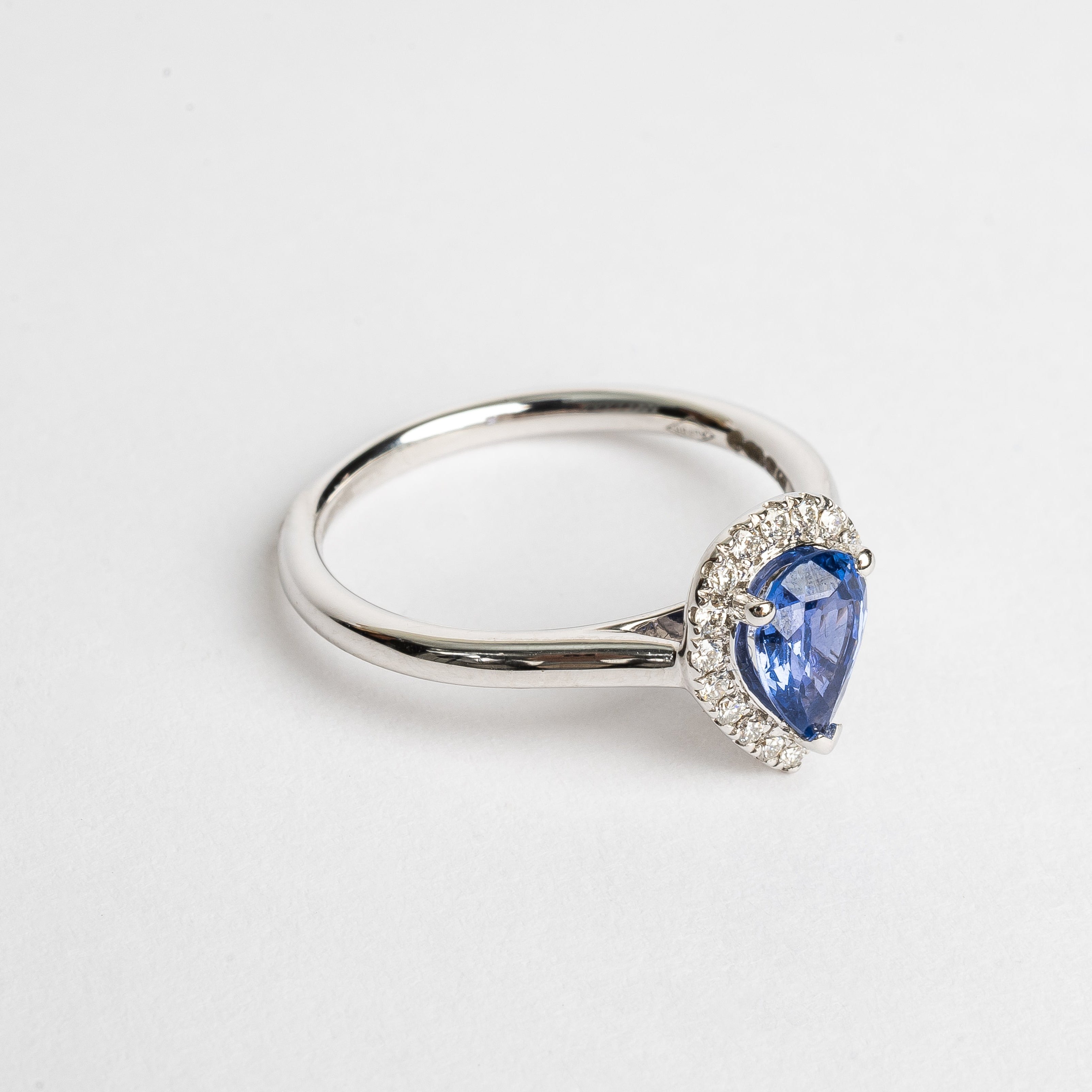 This white golden ring with a pear cut blue Sapphire is timeless. The blue Sapphire is surrounded by a halo of diamonds. The blue of the Sapphire and the white metal color match perfectly together.   The blue Sapphire gives your look a nice pop of color.   The pear cut is the most wanted fance shape.