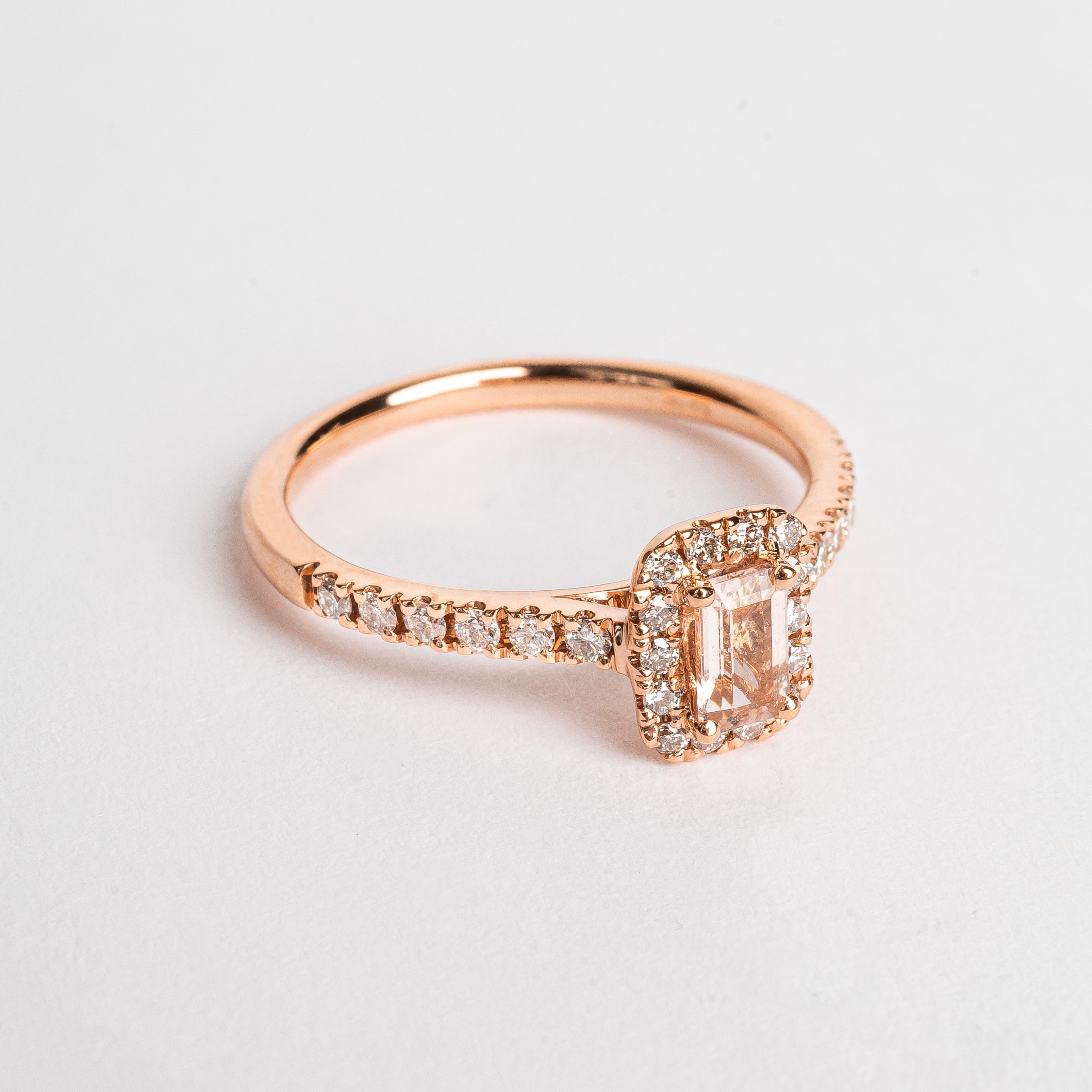 This gorgeous emerald cut Morganite ring made of rose gold is so pretty. The band is set with diamonds and the Marganite emerald cut is surround by a diamond halo. This fancy shape Morganite gemstone is pink. The rose gold and the pink Morganite are a true match.   18kt rose gold 