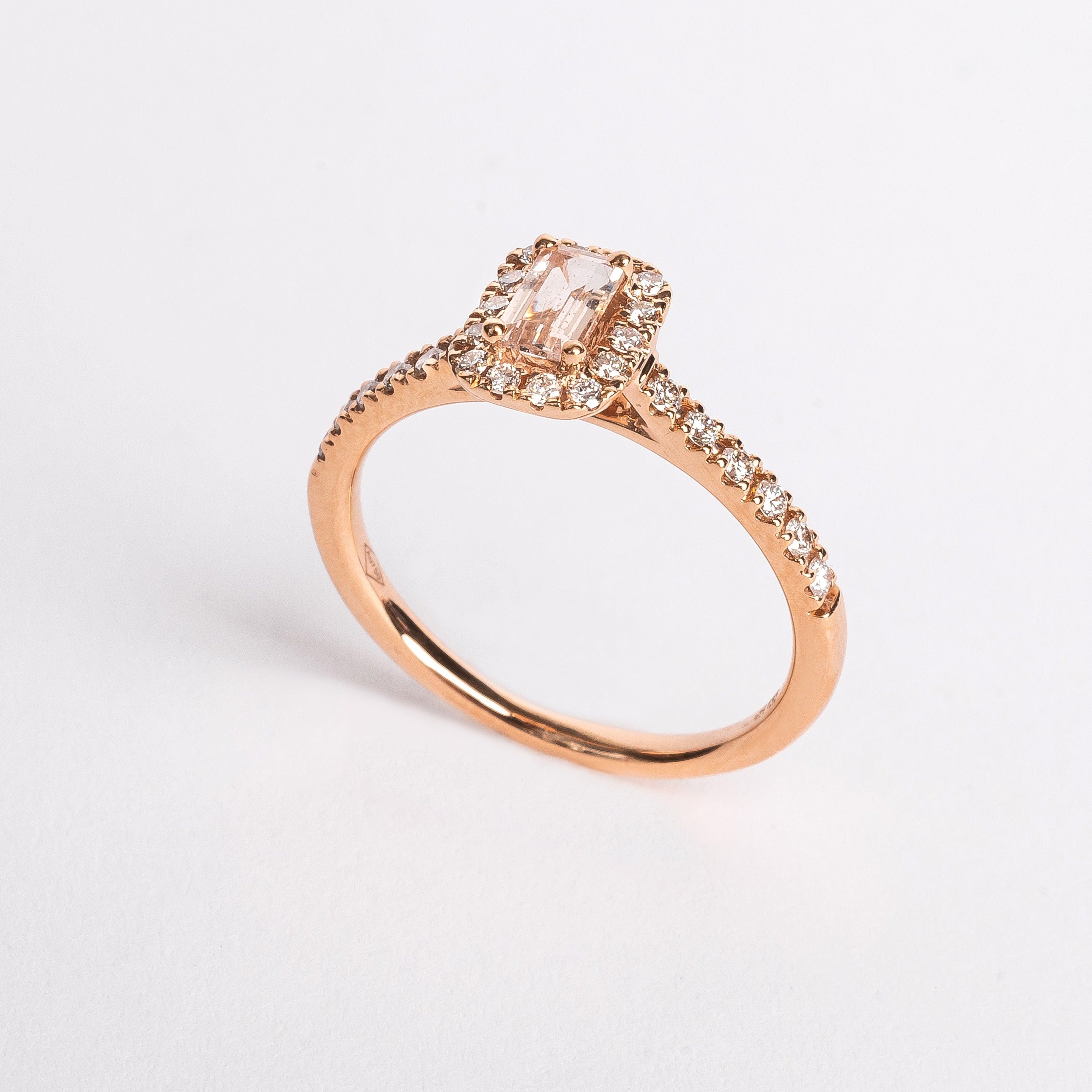 This gorgeous emerald cut Morganite ring made of rose gold is so pretty. The band is set with diamonds and the Marganite emerald cut is surround by a diamond halo. This fancy shape Morganite gemstone is pink. The rose gold and the pink Morganite are a true match.   18kt rose gold 