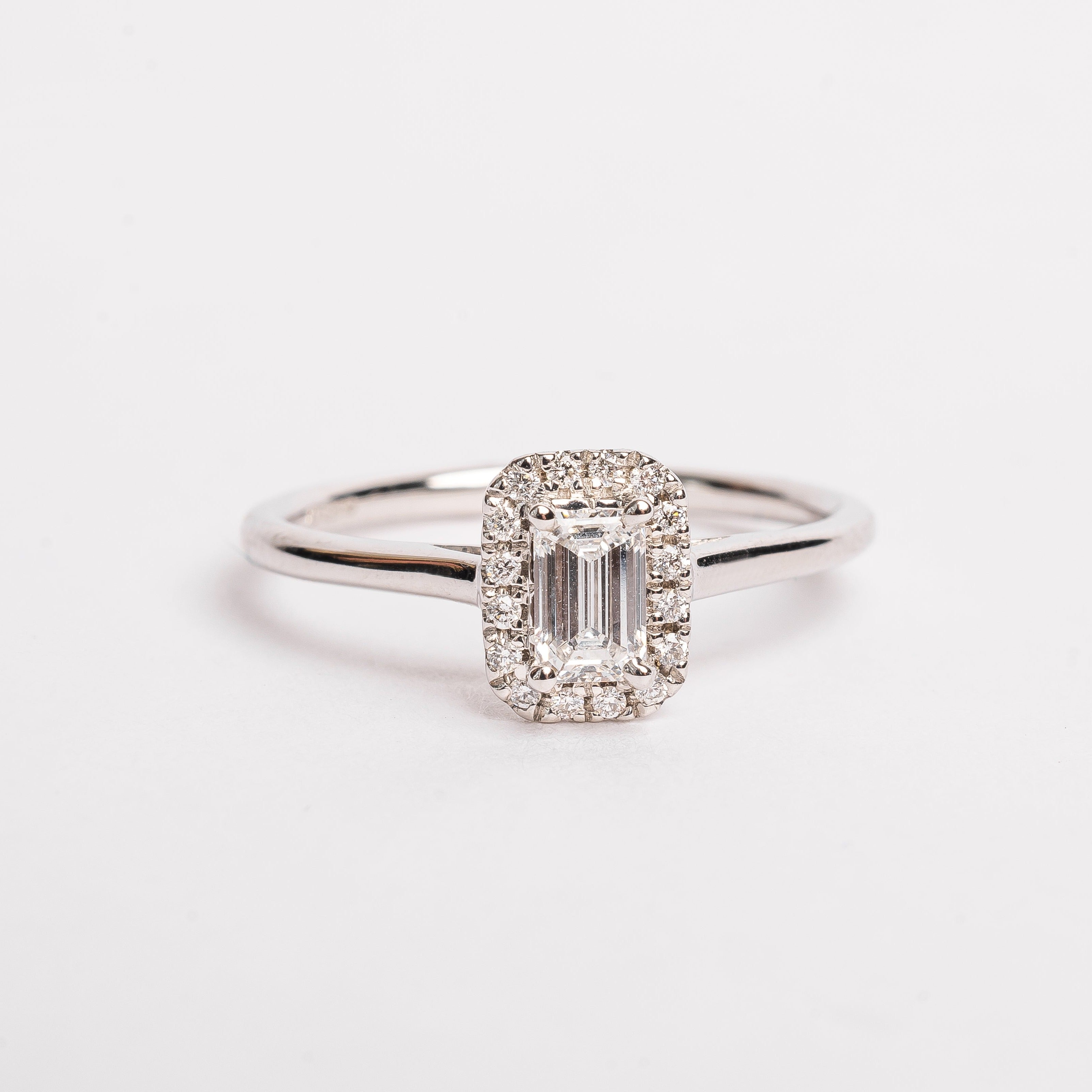 This gorgeous emerald cut Diamond ring made of white gold is beautiful. The band is plain and simple, this makes the diamond with the diamond halo stunning on your hand. This ring is made too fit a wedding band. 