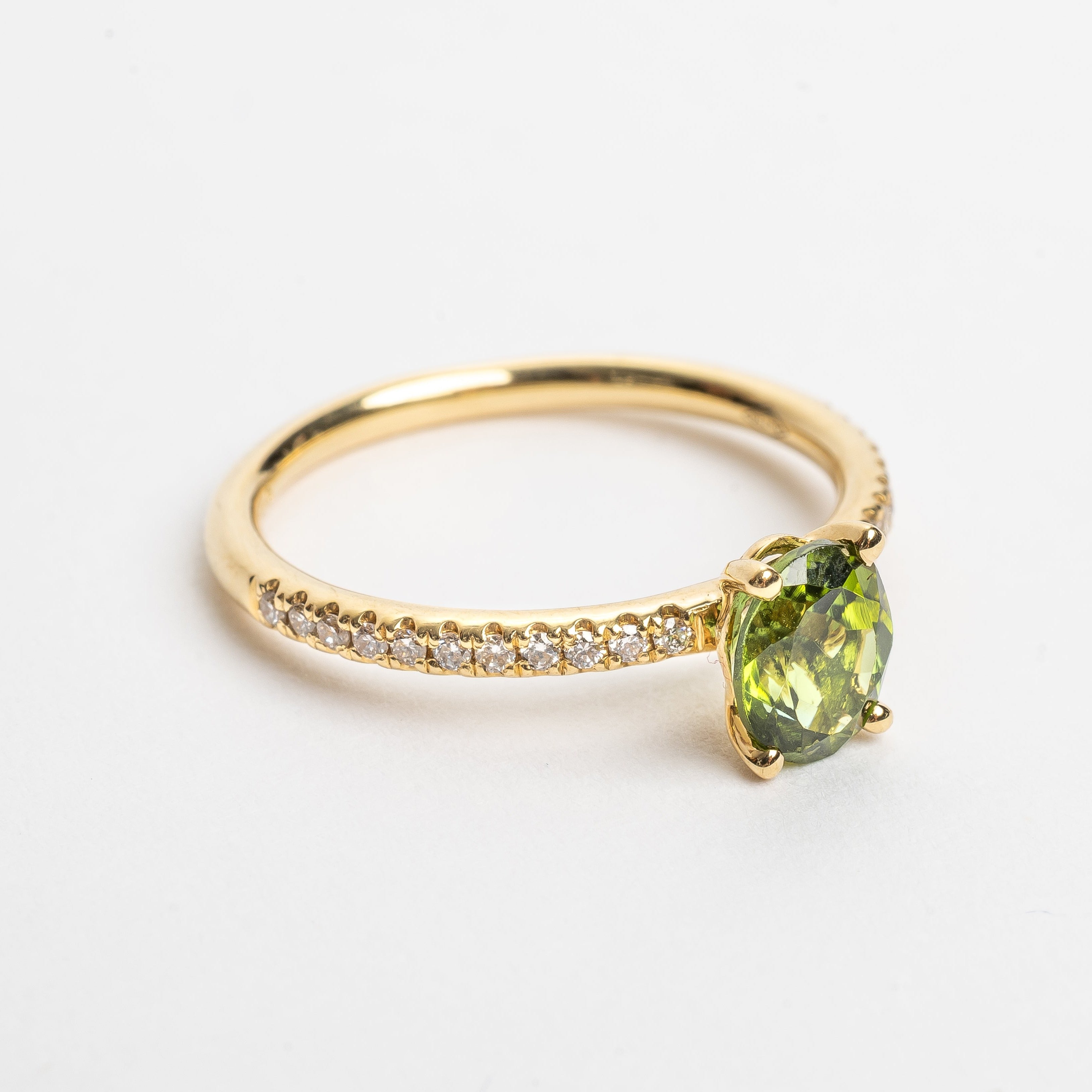 This beautiful oval cut green Tourmaline ring gives your look sparkle and color. Green is a beautiful color that many will love and notice when wearing this ring.   18kt yellow gold Total diamond weight approx. 0.12ct round brilliant diamonds Oval cut green Tourmaline 6.0 x 4.0mm