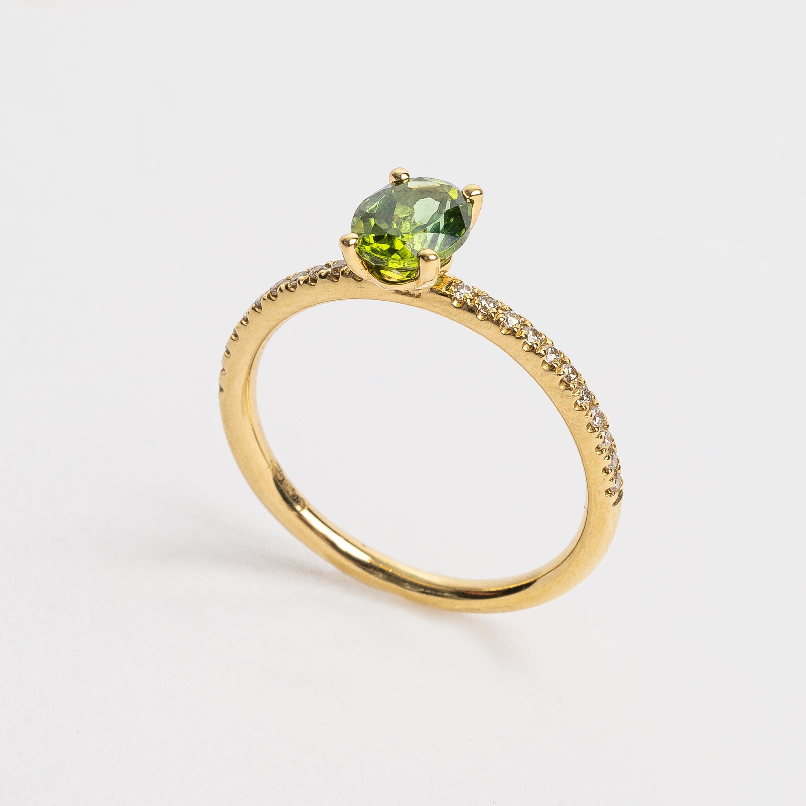 This beautiful oval cut green Tourmaline ring gives your look sparkle and color. Green is a beautiful color that many will love and notice when wearing this ring.   18kt yellow gold Total diamond weight approx. 0.12ct round brilliant diamonds Oval cut green Tourmaline 6.0 x 4.0mm