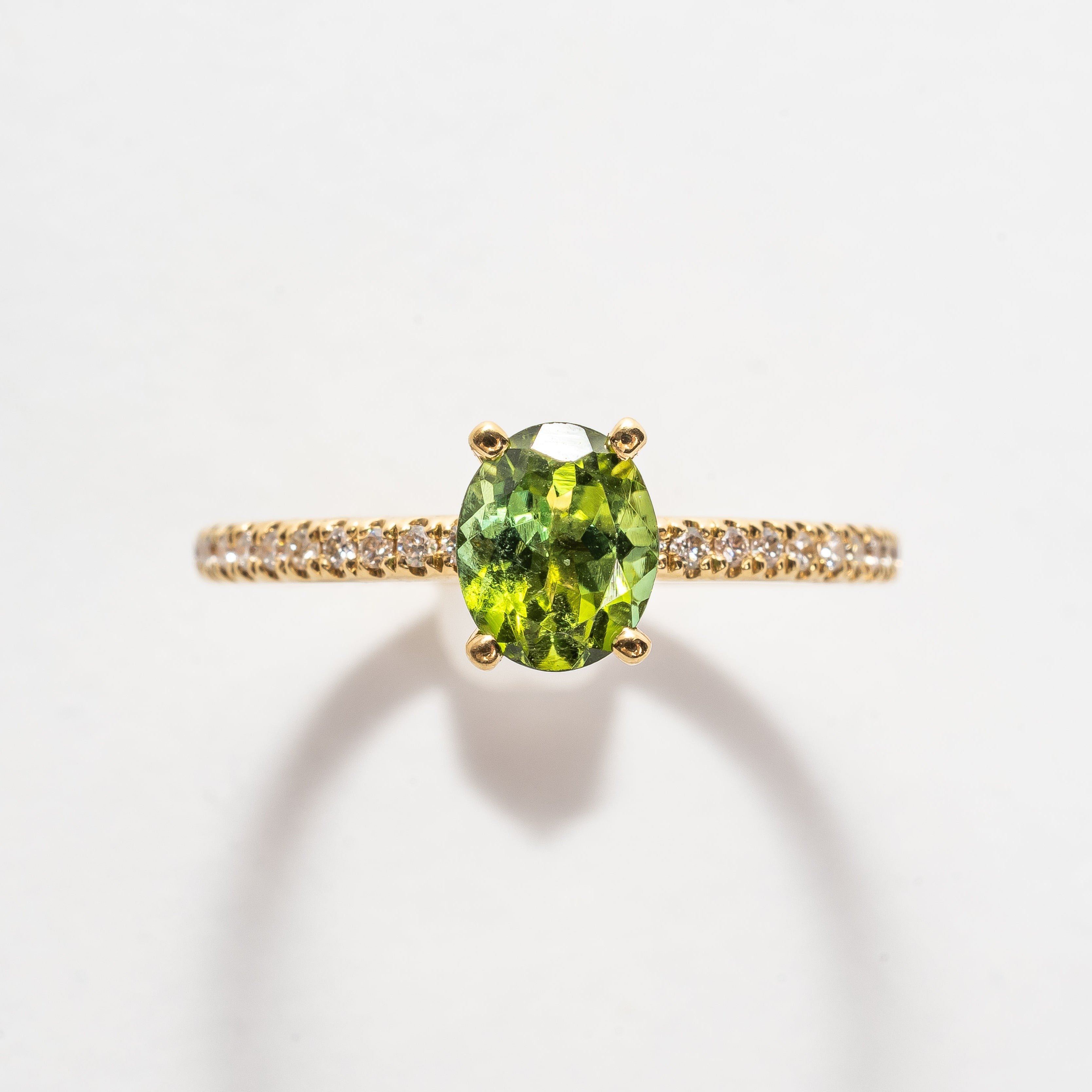 This beautiful oval cut green Tourmaline ring gives your look sparkle and color. Green is a beautiful color that many will love and notice when wearing this ring.   18kt yellow gold Total diamond weight approx. 0.12ct round brilliant diamonds Oval cut green Tourmaline 6.0 x 4.0mm