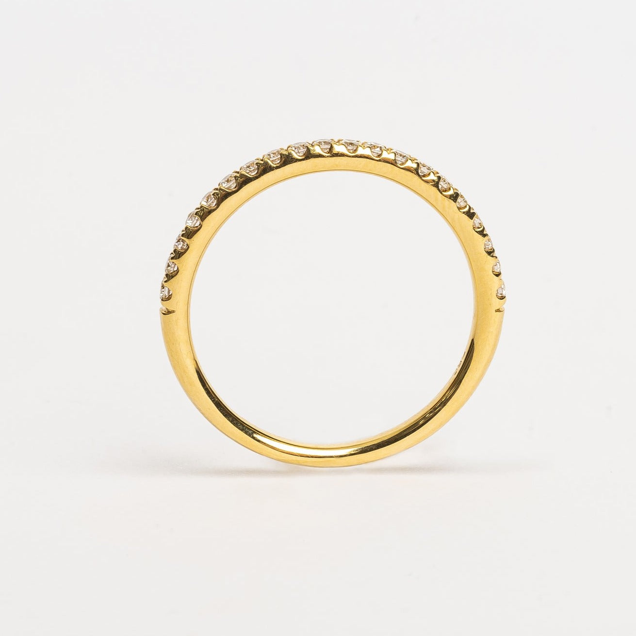 This beautiful yellow golden eternity ring is 50 % set with diamonds. Every diamond is set with 4 claws, these diamonds are not going anywhere. The claws between every diamond and the diamonds itself make the ring sparkle from every side. It's a beautiful addition to your stack, can be worn as a wedding ring next to and engagement ring or alone on any finger. 