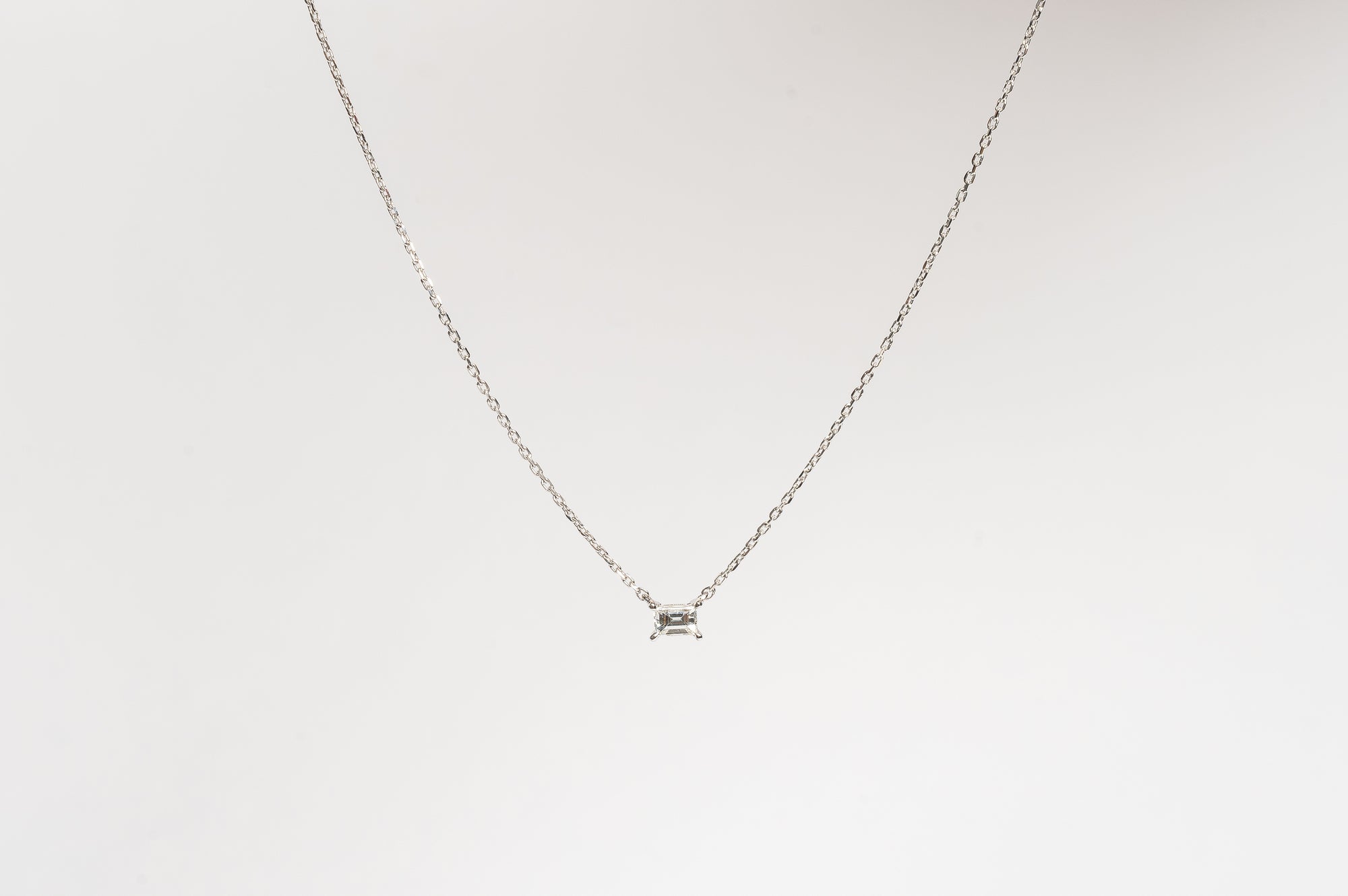 This mini baguette necklace is so refined and elegant. This necklace gives your neck a subtle touch of sparkle. This necklace is elegant by itself, but also very nice to layer with other necklaces.   18kt white gold 4.4 mm x 3.3 mm Baguette stone set with four claws Total diamond weight for the baguette is approx. 0.20ct Necklace length 40cm