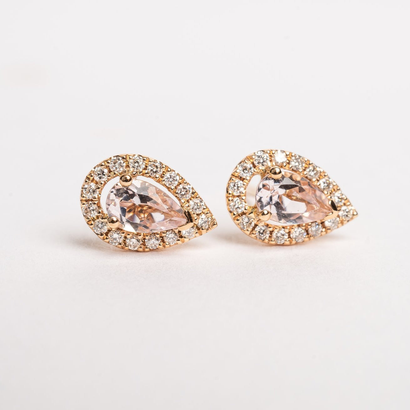 A pear is the most sold fancy shape on the market, they are hot. These Pear peach Morganite and diamonds halo studs are pretty and fit on all ears.   18kt rose gold