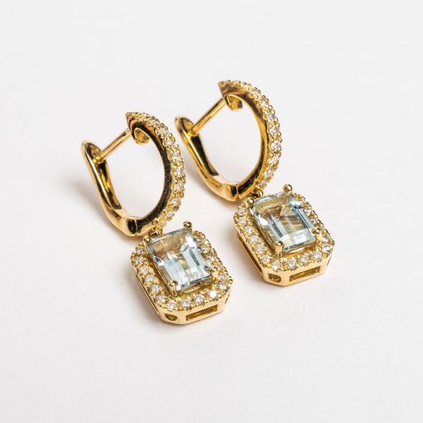 These beautiful pendant earrings with a blue Emerald cut Aquamarine center stone are elegant and finish every look.  The blue makes you happy and compliment your eyes.   18kt yellow gold  6mm x 4mm Emerald cut blue Aquamarine each earring 