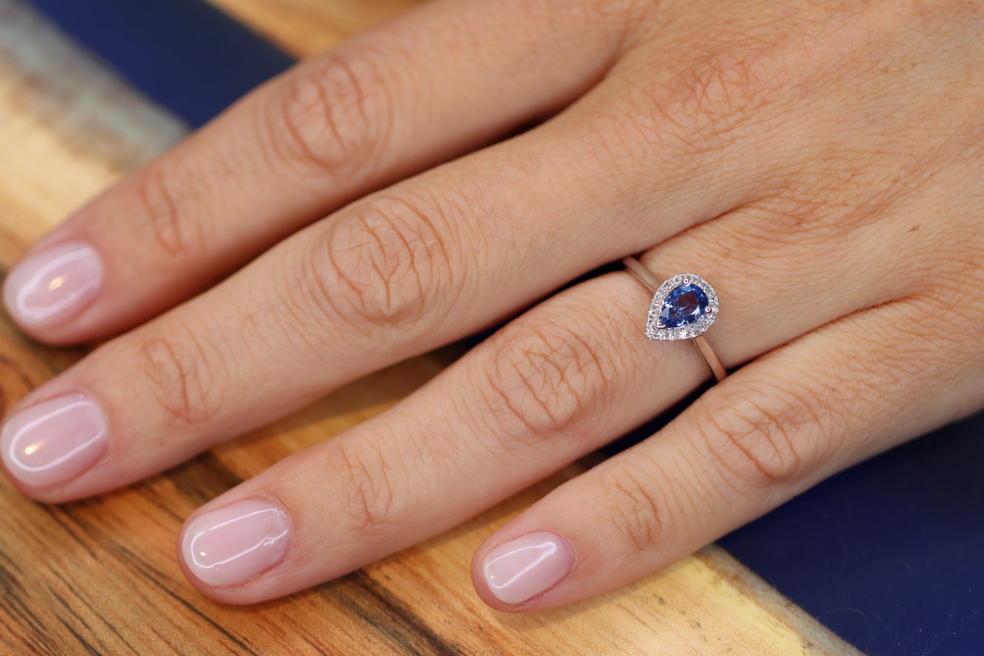 This white golden ring with a pear cut blue Sapphire is timeless. The blue Sapphire is surrounded by a halo of diamonds. The blue of the Sapphire and the white metal color match perfectly together.   The blue Sapphire gives your look a nice pop of color.   The pear cut is the most wanted fance shape. On my own hand. 